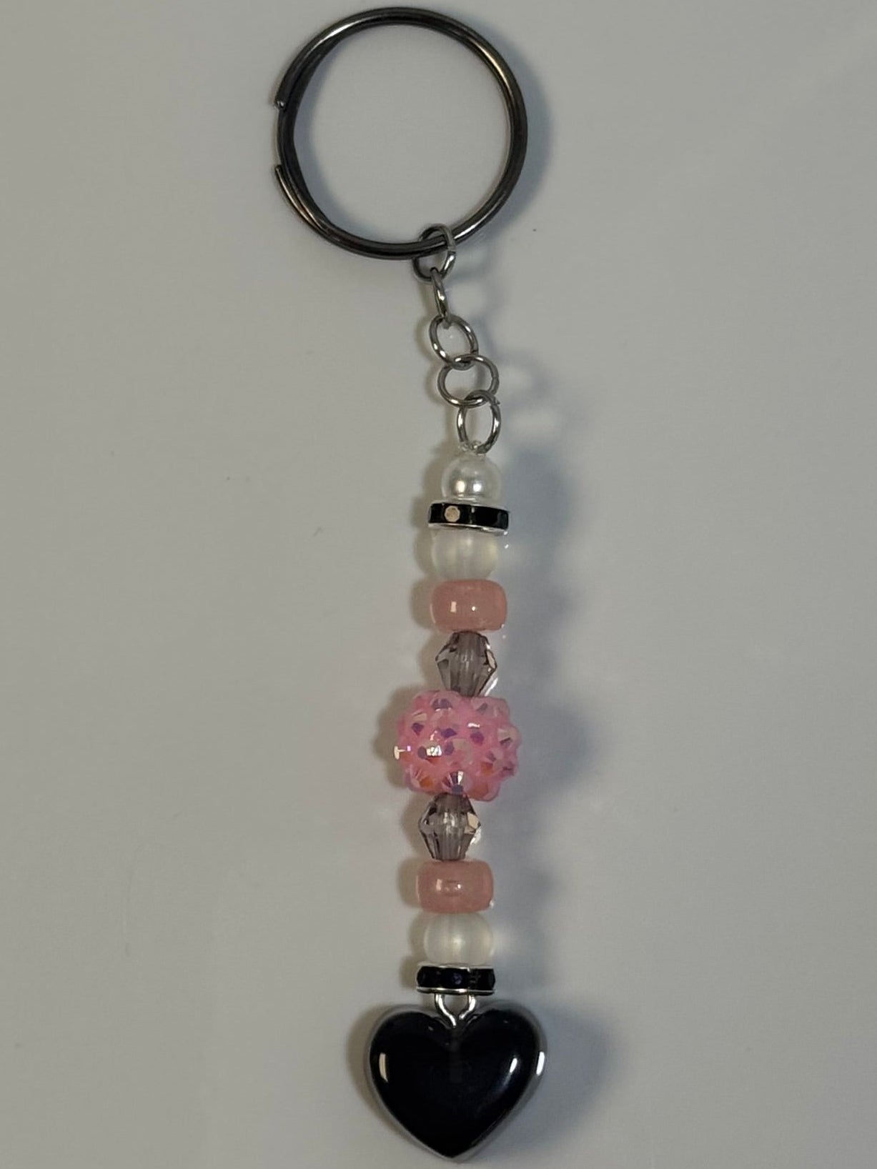 Keychain with beads and a heart charm on a marble surface