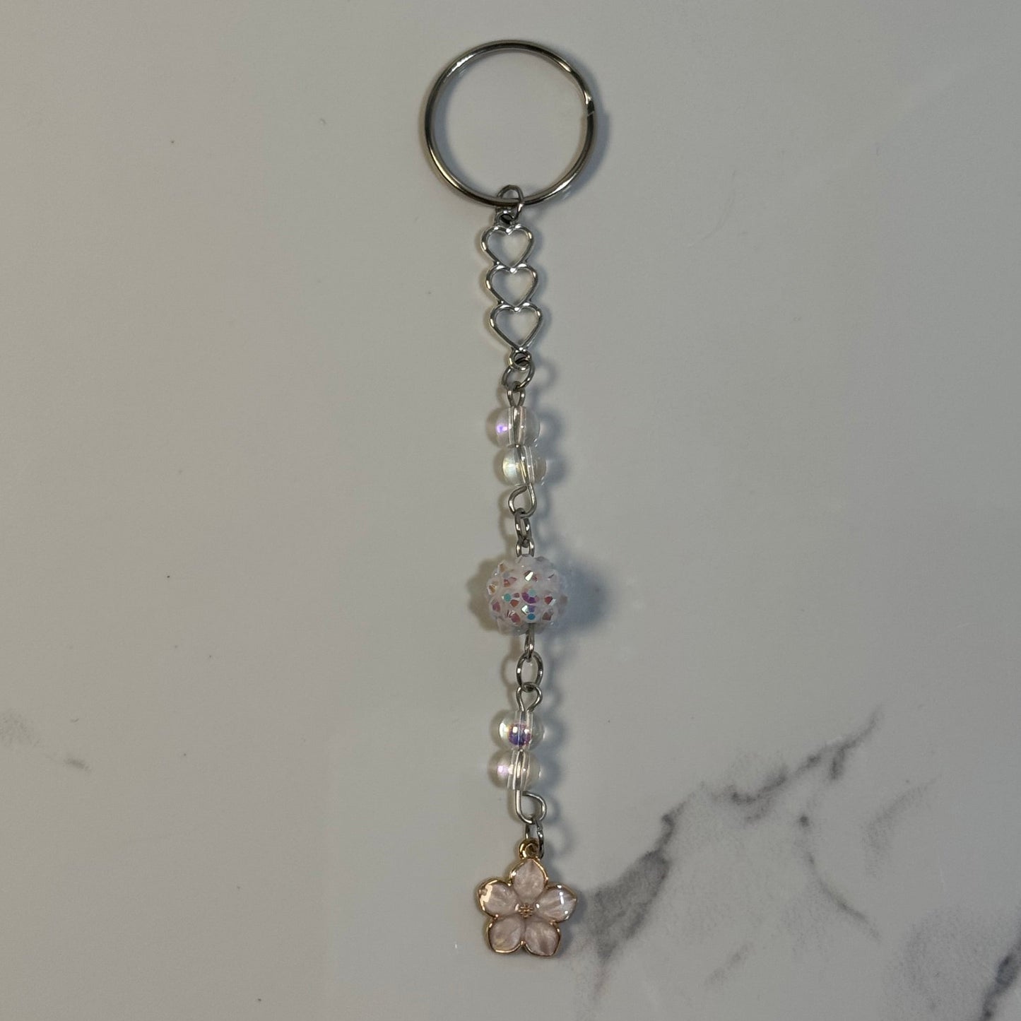 Keychain with beads and a small decorative item on a marble surface