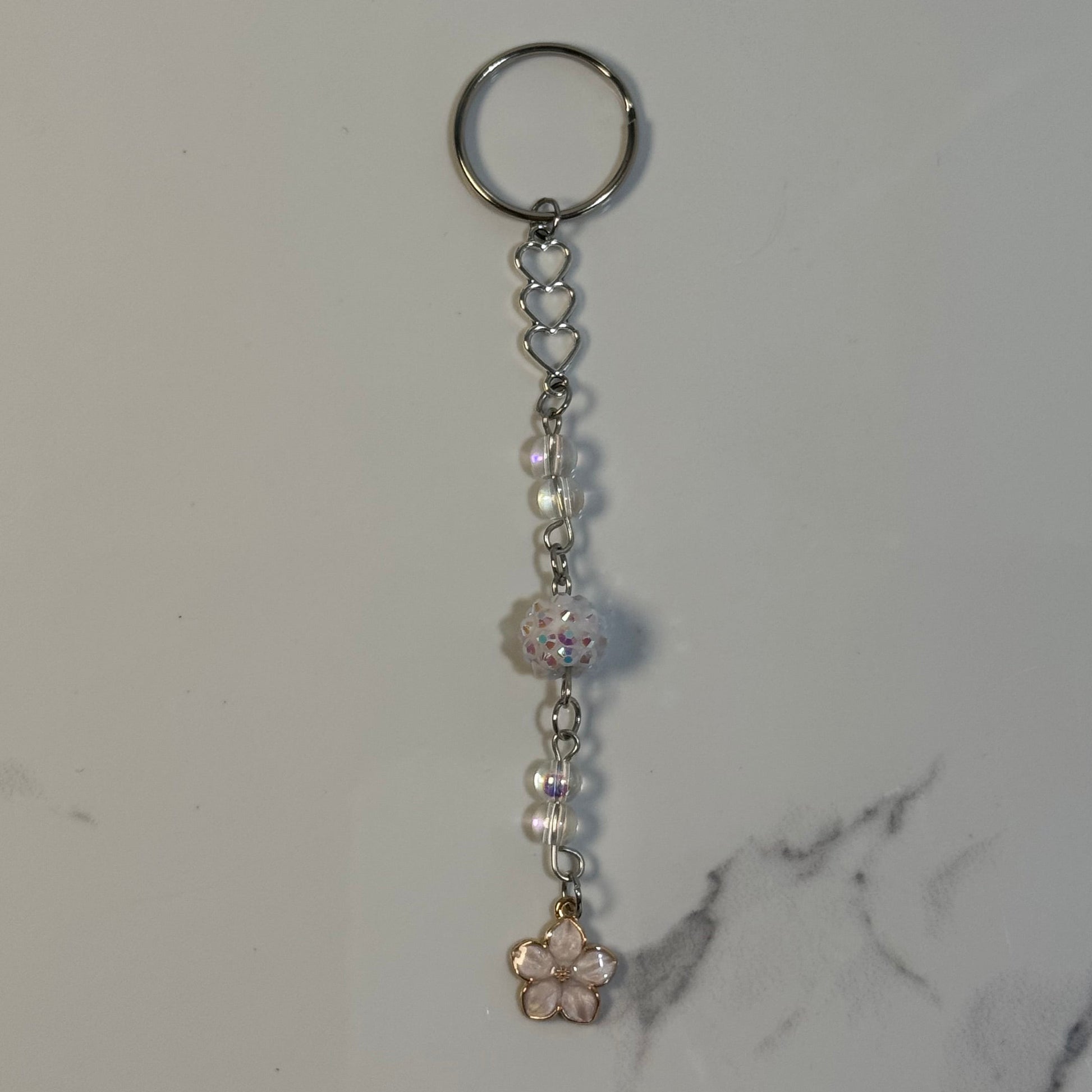 Keychain with beads and a small decorative item on a marble surface