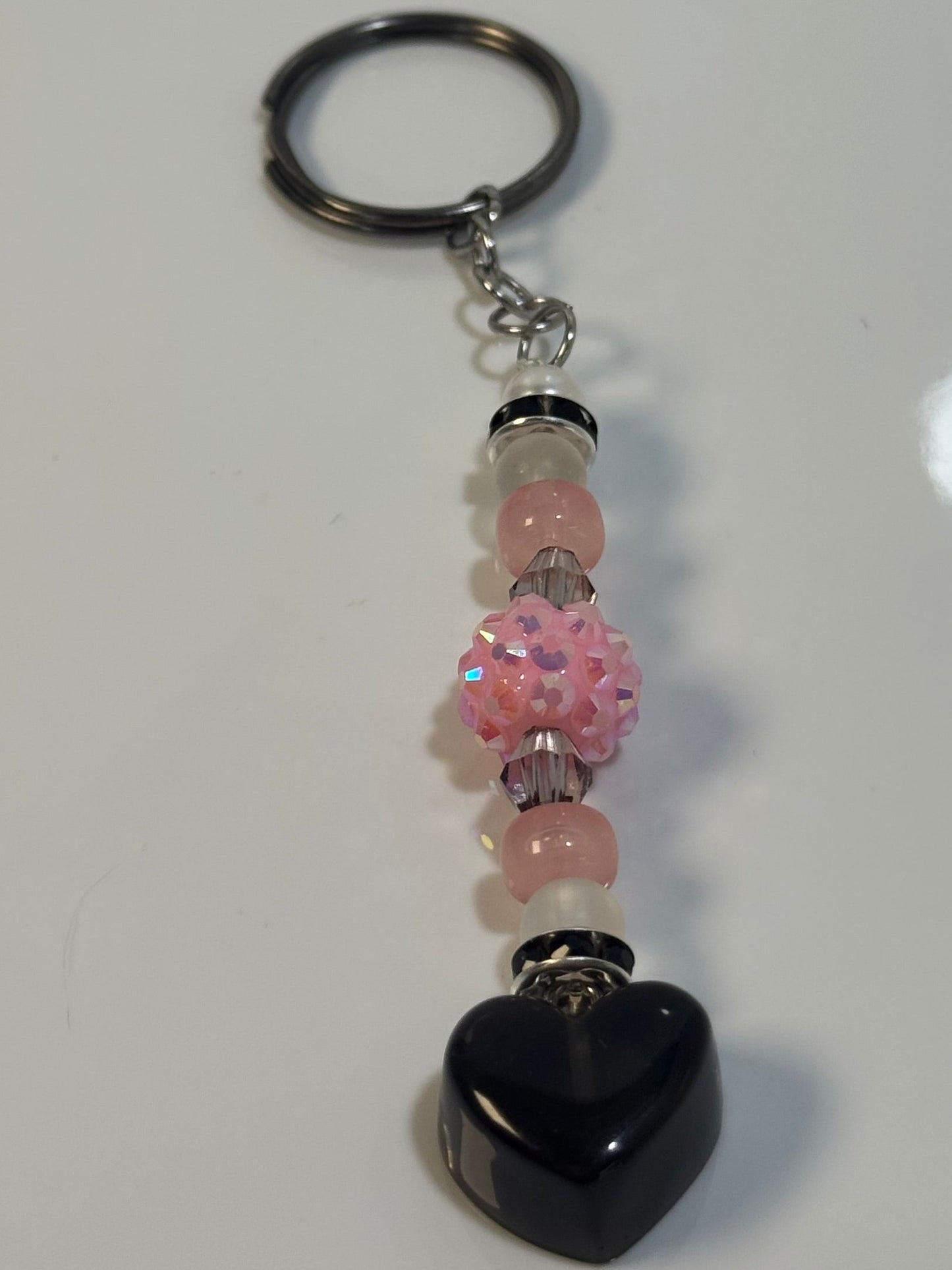 Keychain with pink beads on a white marble surface