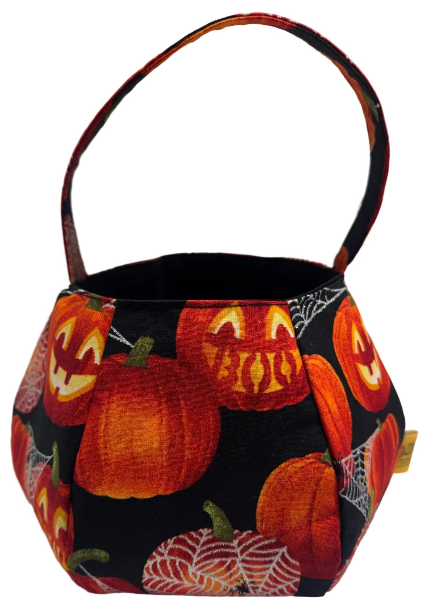 A small fabric bucket-style bag with a Halloween pumpkin print, featuring carved and smiling pumpkins on a black background with a handle.