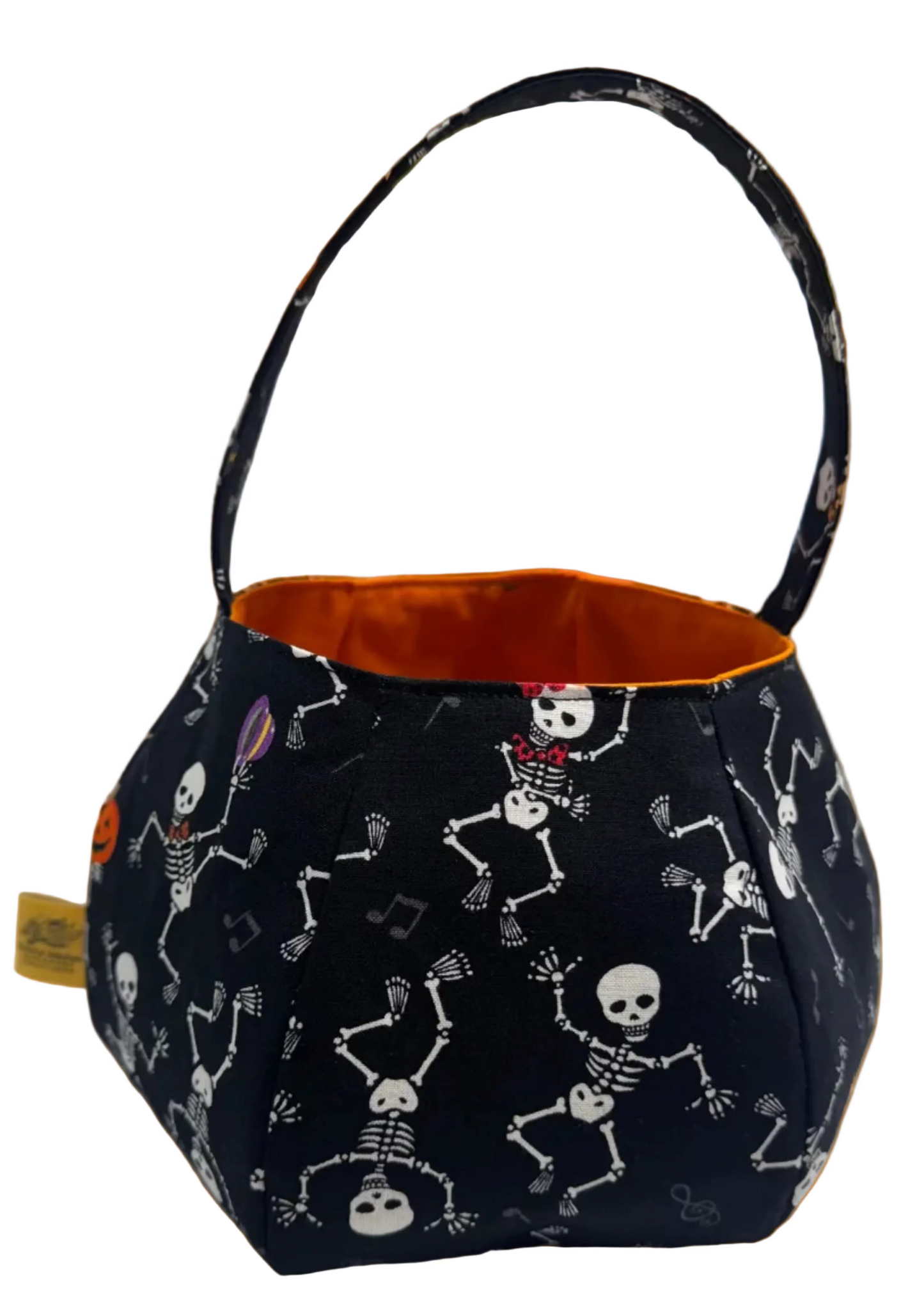 A small fabric bucket-style bag with a black exterior printed with white skeleton figures, a black handle, and an orange interior.